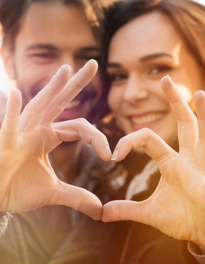Closeup of couple making heart shape with hands