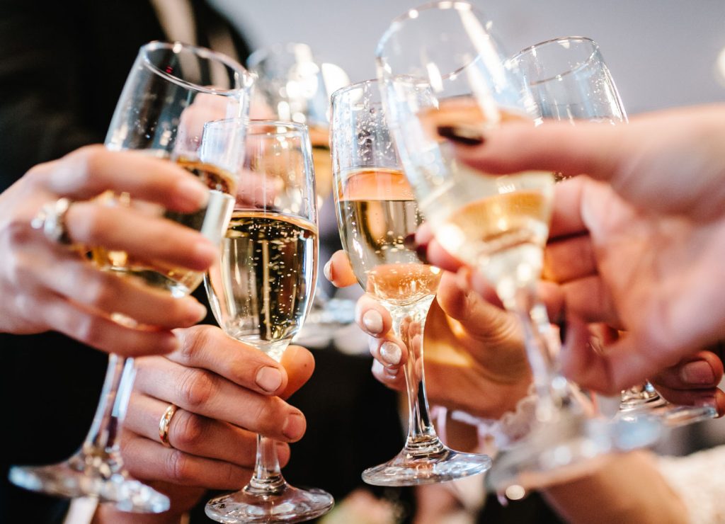 People celebrate and raise glasses of fizz for toast.